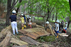 カヤなどを使って千葉家の裏山でひみつきちを作る子どもたち